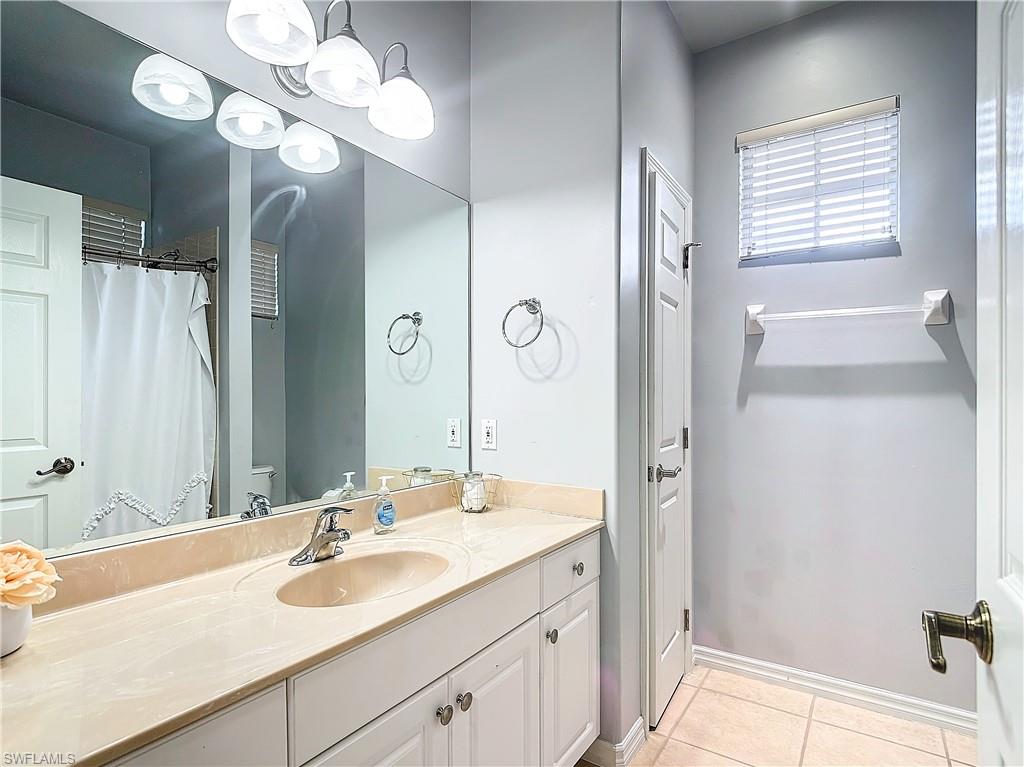12854 Carrington Circle, Unit 204 Naples, FL 34105 - Photo 17 of 37 a bathroom with a sink double vanity granite tub shower and a mirror
