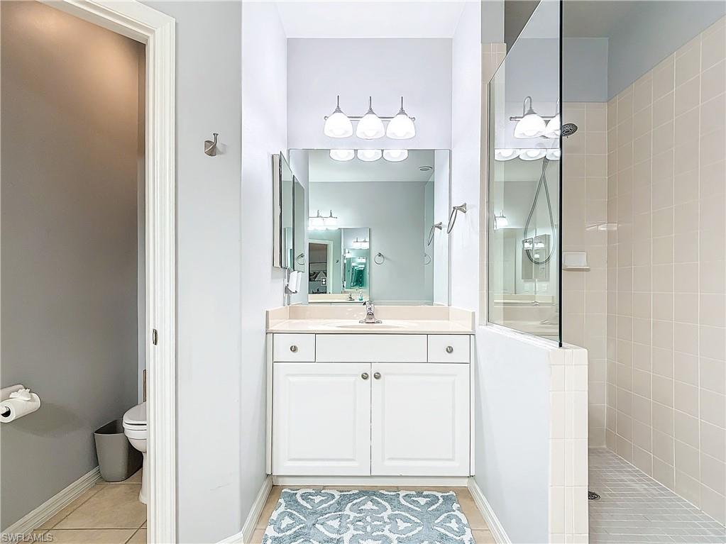 12854 Carrington Circle, Unit 204 Naples, FL 34105 - Photo 22 of 37 a bathroom with a sink mirror and a toilet