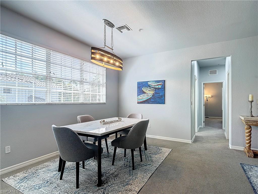12854 Carrington Circle, Unit 204 Naples, FL 34105 - Photo 3 of 37 a view of a dining room with furniture window and wooden floor