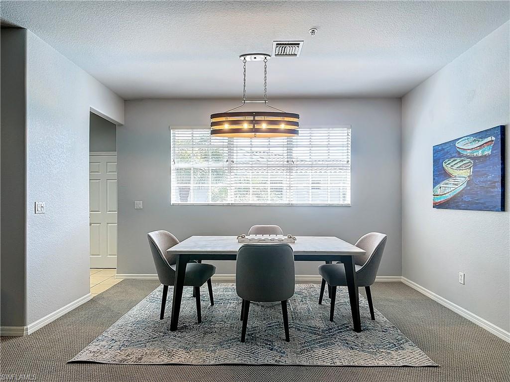 12854 Carrington Circle, Unit 204 Naples, FL 34105 - Photo 4 of 37 a view of a dining room with furniture window and wooden floor