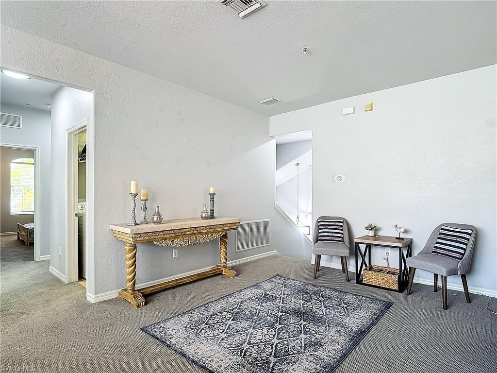 12854 Carrington Circle, Unit 204 Naples, FL 34105 - Photo 5 of 37 a living room with furniture and a rug