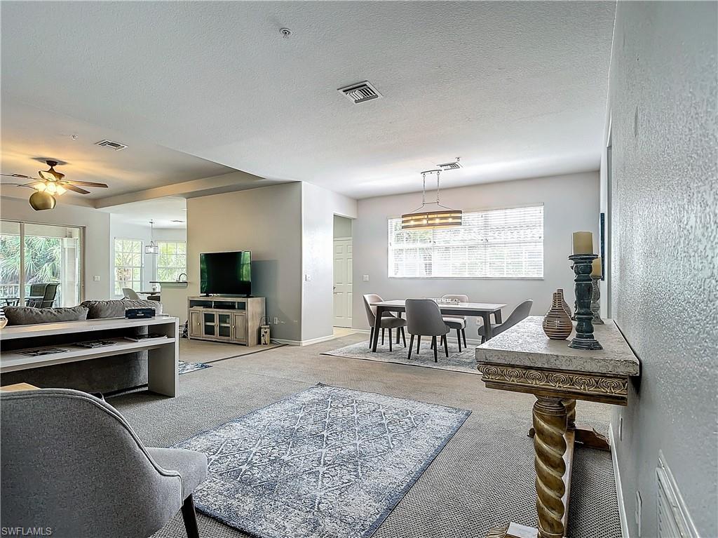 12854 Carrington Circle, Unit 204 Naples, FL 34105 - Photo 6 of 37 a living room with furniture a rug and a flat screen tv