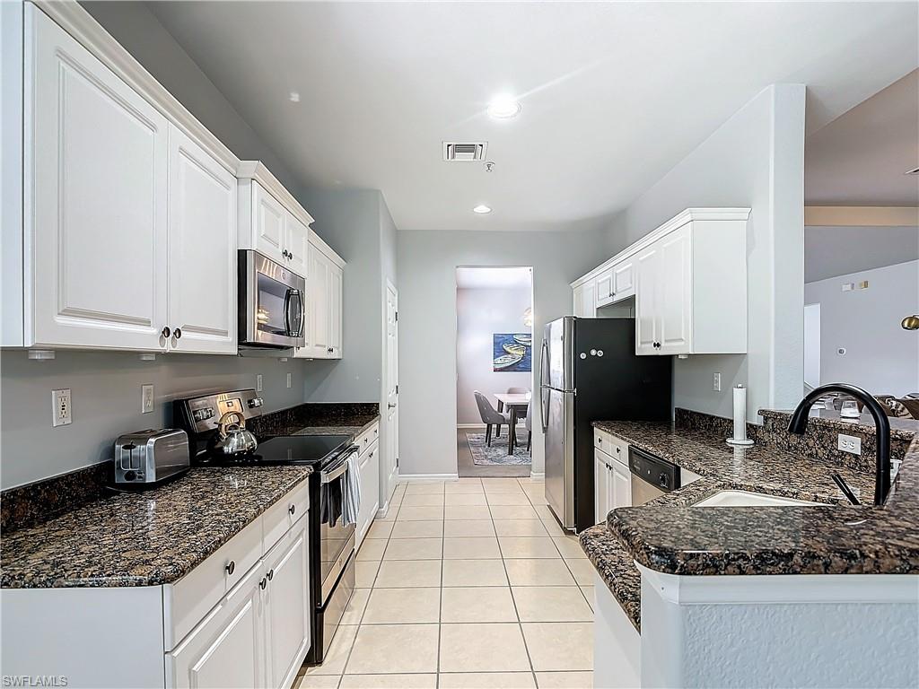 12854 Carrington Circle, Unit 204 Naples, FL 34105 - Photo 9 of 37 a kitchen with stainless steel appliances granite countertop a sink stove and refrigerator