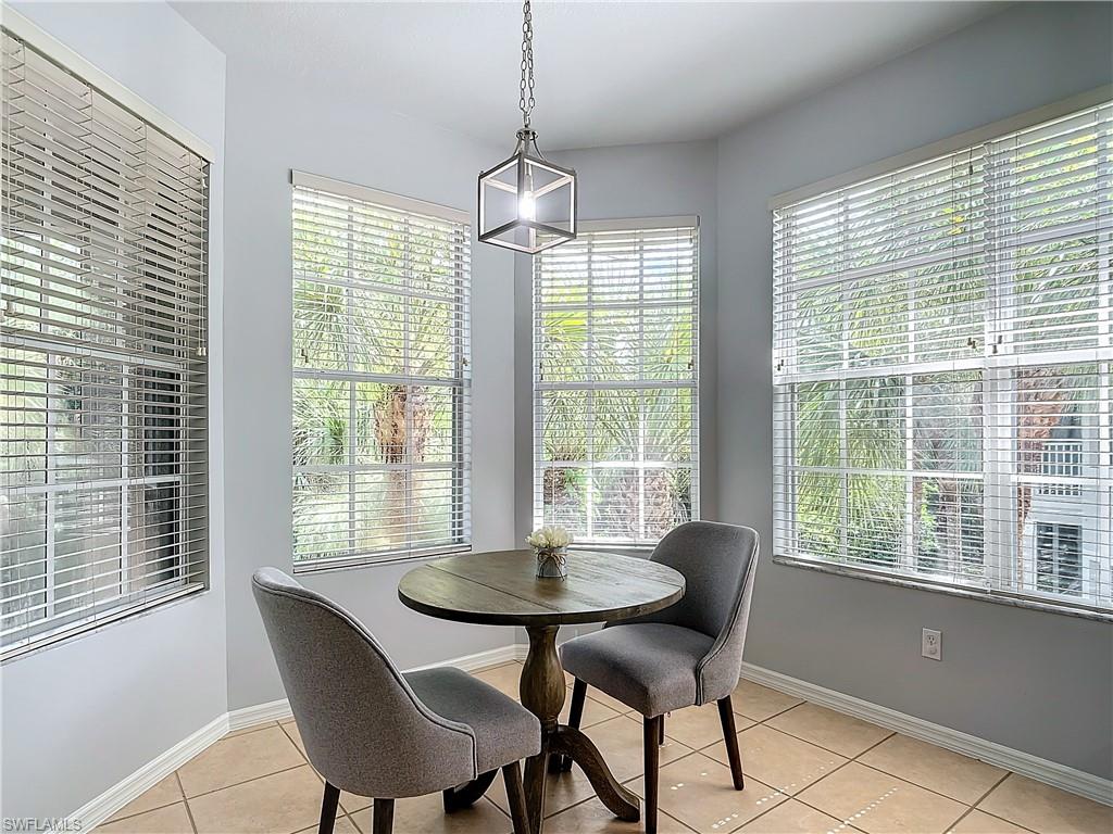 12854 Carrington Circle, Unit 204 Naples, FL 34105 - Photo 10 of 37 a dining room with furniture a chandelier and wooden floor