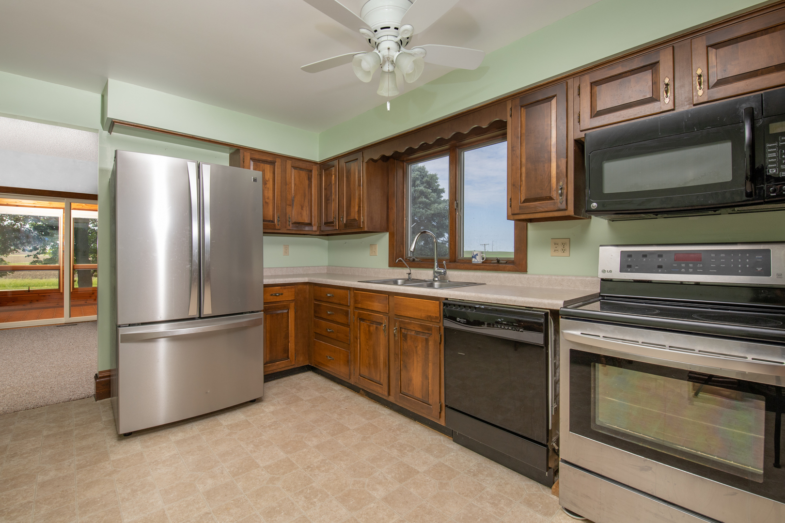 6135 Base Line Road Kirkland, IL 60146 - Photo 34 of 48 a kitchen with stainless steel appliances granite countertop a refrigerator stove a sink and dishwasher with wooden floor