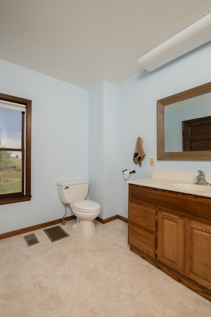 6135 Base Line Road Kirkland, IL 60146 - Photo 44 of 48 a bathroom with a toilet a sink and mirror
