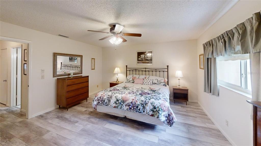8592 Southwest 91 Street, Unit E Ocala, FL 34481 - Photo 12 of 20 a bedroom with a bed chandelier and a window