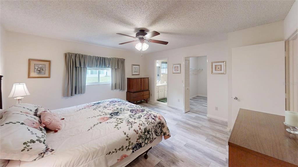 8592 Southwest 91 Street, Unit E Ocala, FL 34481 - Photo 13 of 20 a bedroom with a bed and a chandelier
