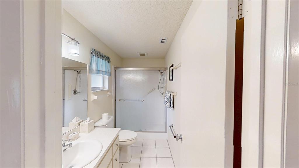 8592 Southwest 91 Street, Unit E Ocala, FL 34481 - Photo 15 of 20 a bathroom with a granite countertop sink toilet and shower