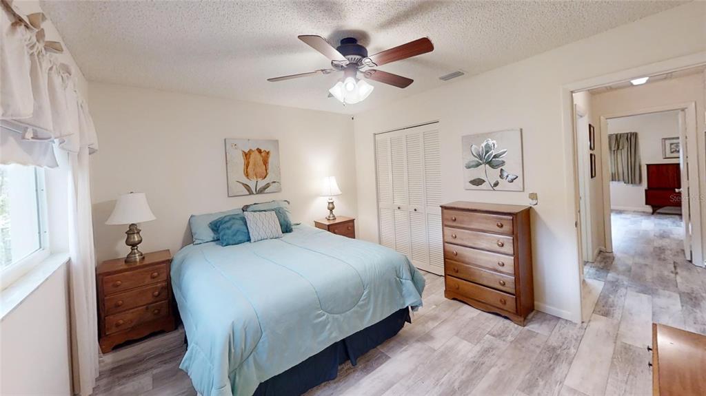 8592 Southwest 91 Street, Unit E Ocala, FL 34481 - Photo 16 of 20 a bedroom with a bed and a chandelier