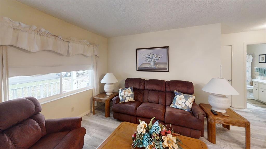 8592 Southwest 91 Street, Unit E Ocala, FL 34481 - Photo 3 of 20 a living room with furniture wooden floor and a window