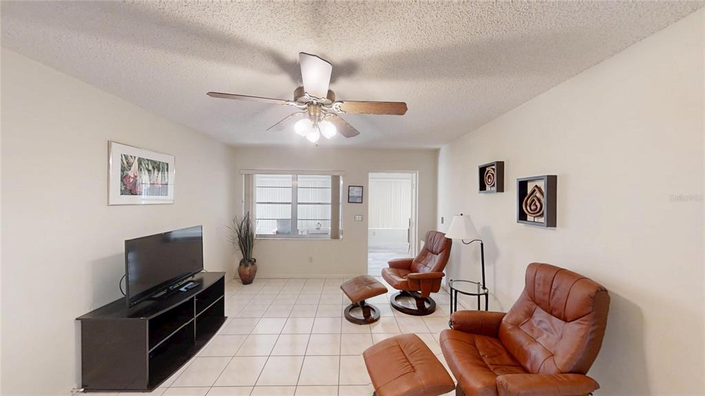 8592 Southwest 91 Street, Unit E Ocala, FL 34481 - Photo 10 of 20 a living room with furniture a flat screen tv and ceiling fan