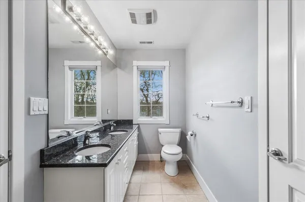 a bathroom with a granite countertop sink a mirror a shower and a bathtub