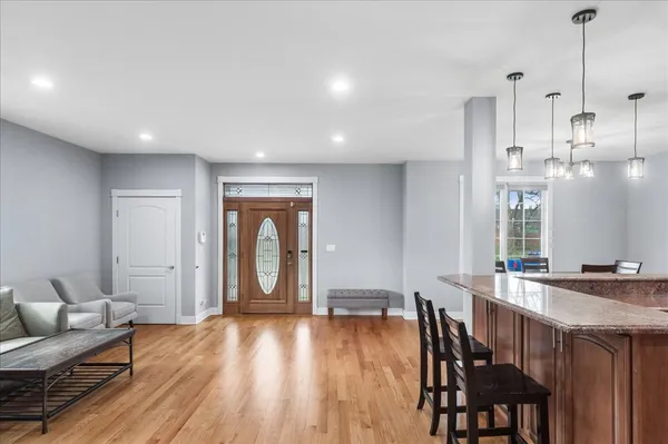 a kitchen with stainless steel appliances granite countertop a table chairs stove and refrigerator
