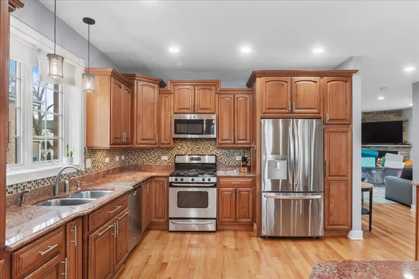 a kitchen with stainless steel appliances granite countertop a stove a sink and a refrigerator