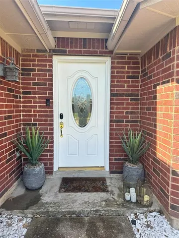 a view of a door of the house with potted plants