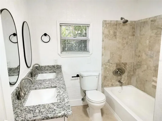 a bathroom with a granite countertop toilet sink and shower