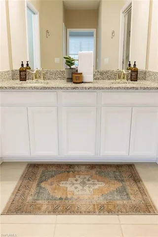 a bathroom with granite countertop a sink and a mirror