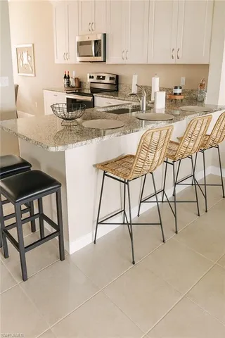 a kitchen with stainless steel appliances granite countertop a stove a sink and a white cabinets