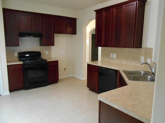 a kitchen with stainless steel appliances granite countertop wooden cabinets a stove and a refrigerator