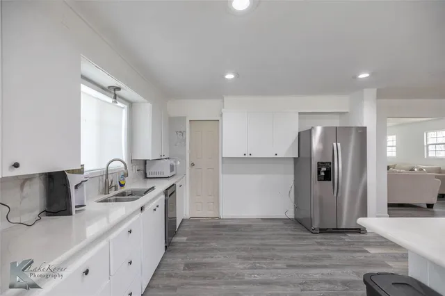 a kitchen with granite countertop a refrigerator and a sink