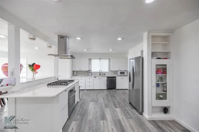 a kitchen with stainless steel appliances a refrigerator and a stove top oven