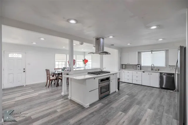 a kitchen with stove and wooden floor