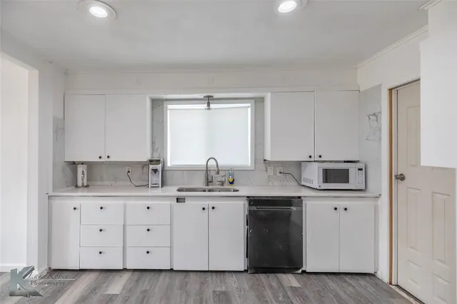 a kitchen with a sink a stove and cabinets