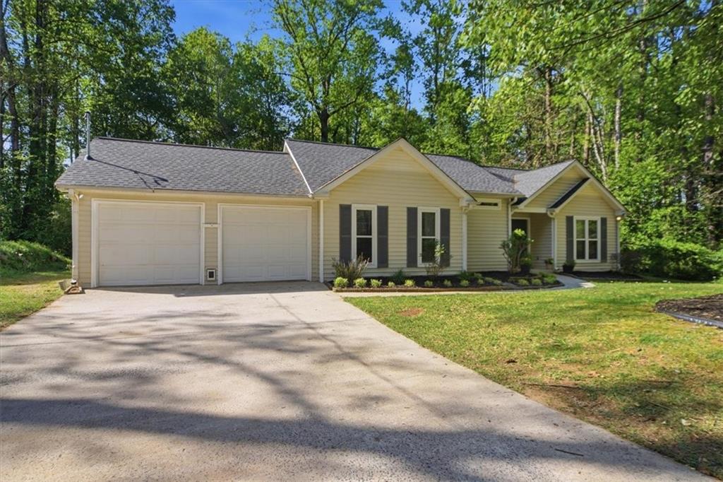 8068 Whitney Court Canton, GA 30115 - Photo 2 of 32 a front view of a house with a garden and porch