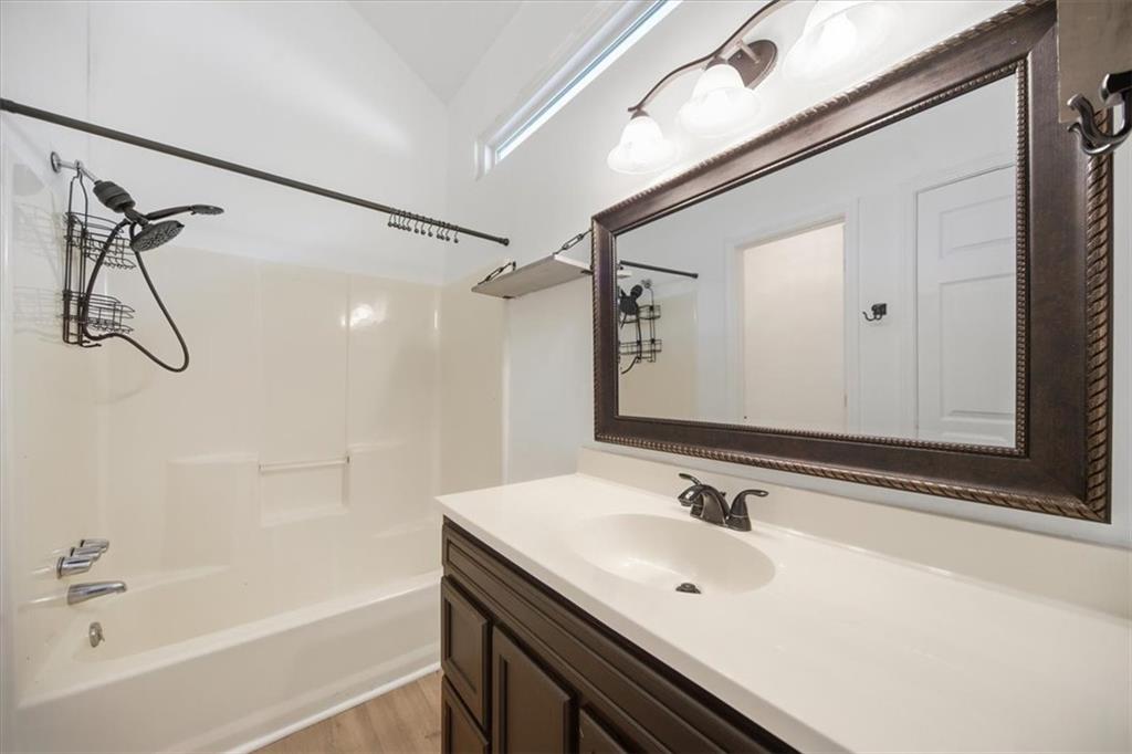 8068 Whitney Court Canton, GA 30115 - Photo 23 of 32 a bathroom with a sink a mirror and a bathtub