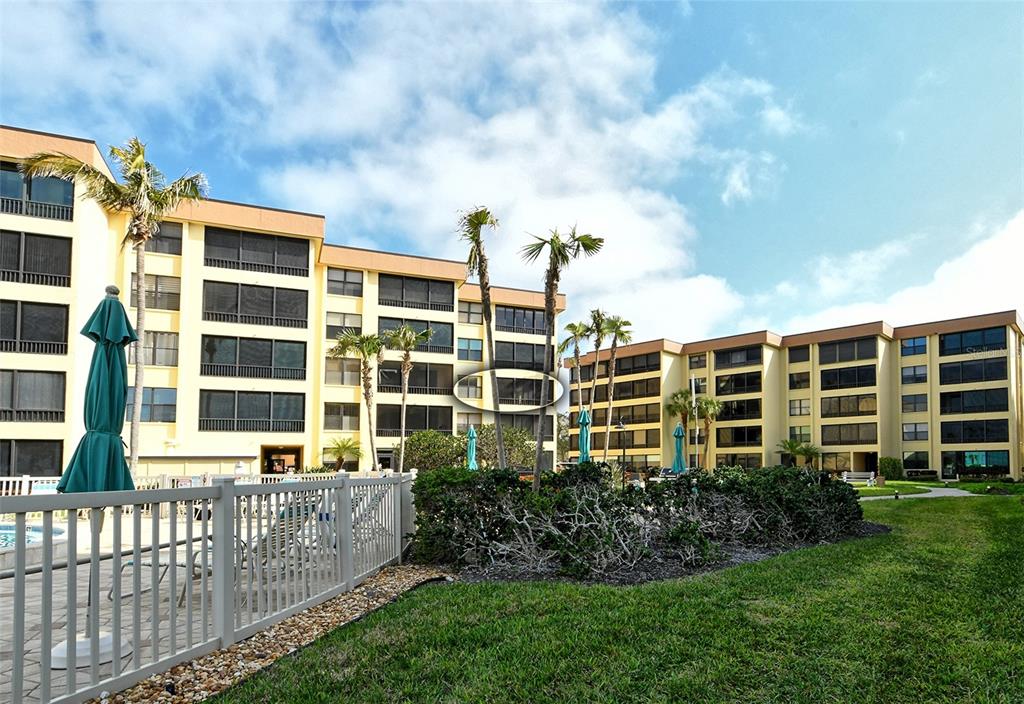 8764 Midnight Pass Road, Unit A306 Sarasota, FL 34242 - Photo 4 of 53 a front view of a building with a garden