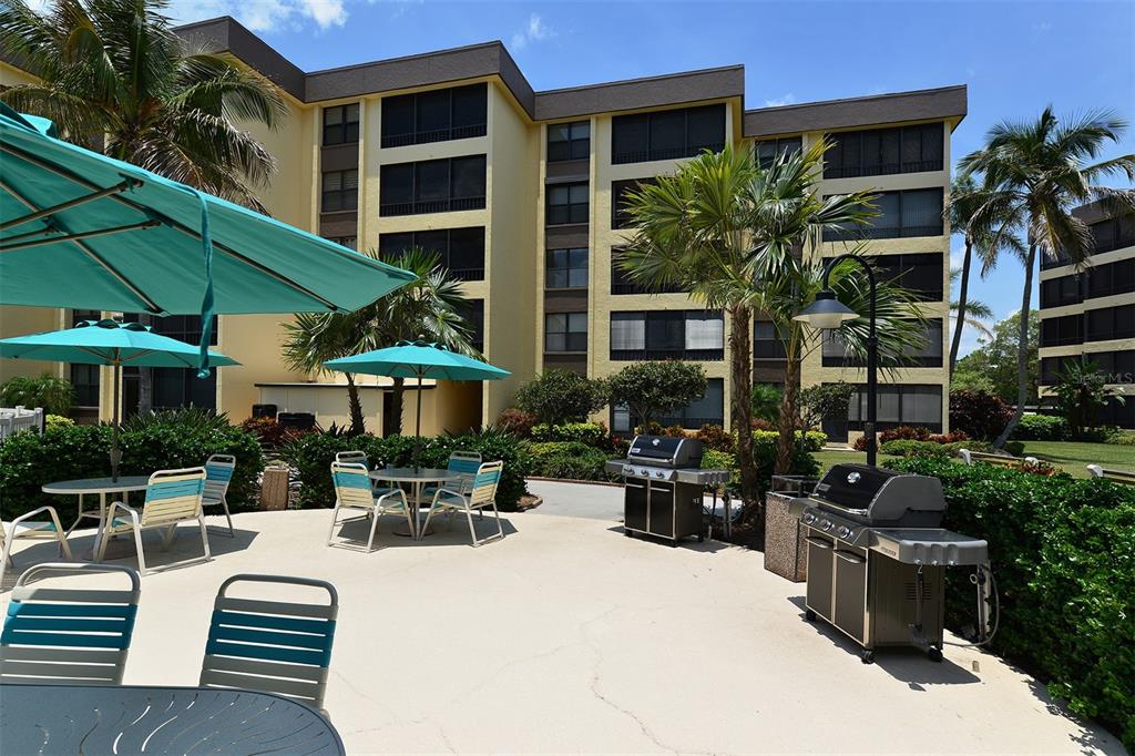 8764 Midnight Pass Road, Unit A306 Sarasota, FL 34242 - Photo 7 of 53 a view of a patio with table and chairs under an umbrella
