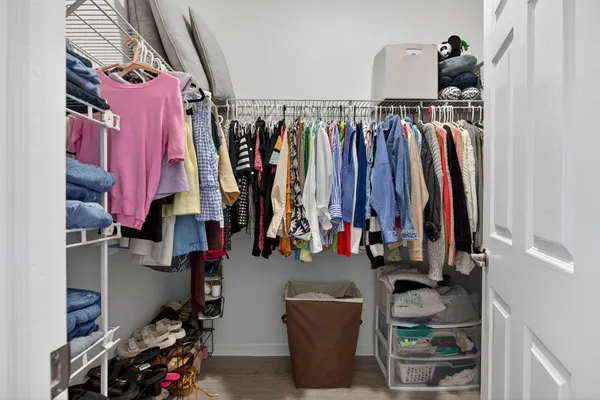 a view of walk in closet with clothes and shoes