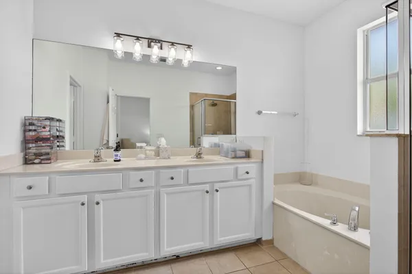 a bathroom with a tub a sink and mirror