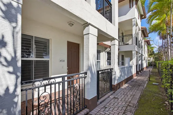 a view of a pathway of a house with wooden fence