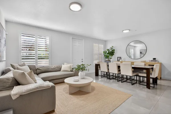 a living room with furniture a window and a large mirror