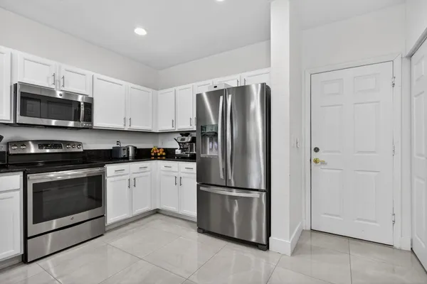 a kitchen with stainless steel appliances granite countertop a refrigerator and a stove top oven