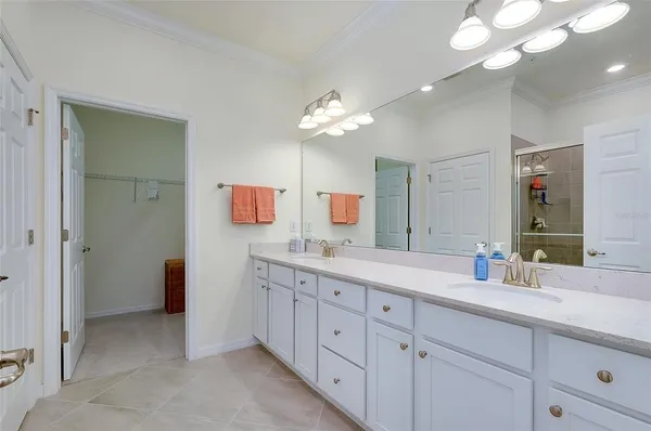 a spacious bathroom with a double vanity sink a mirror and a shower