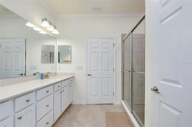 a bathroom with a sink a toilet and a large mirror