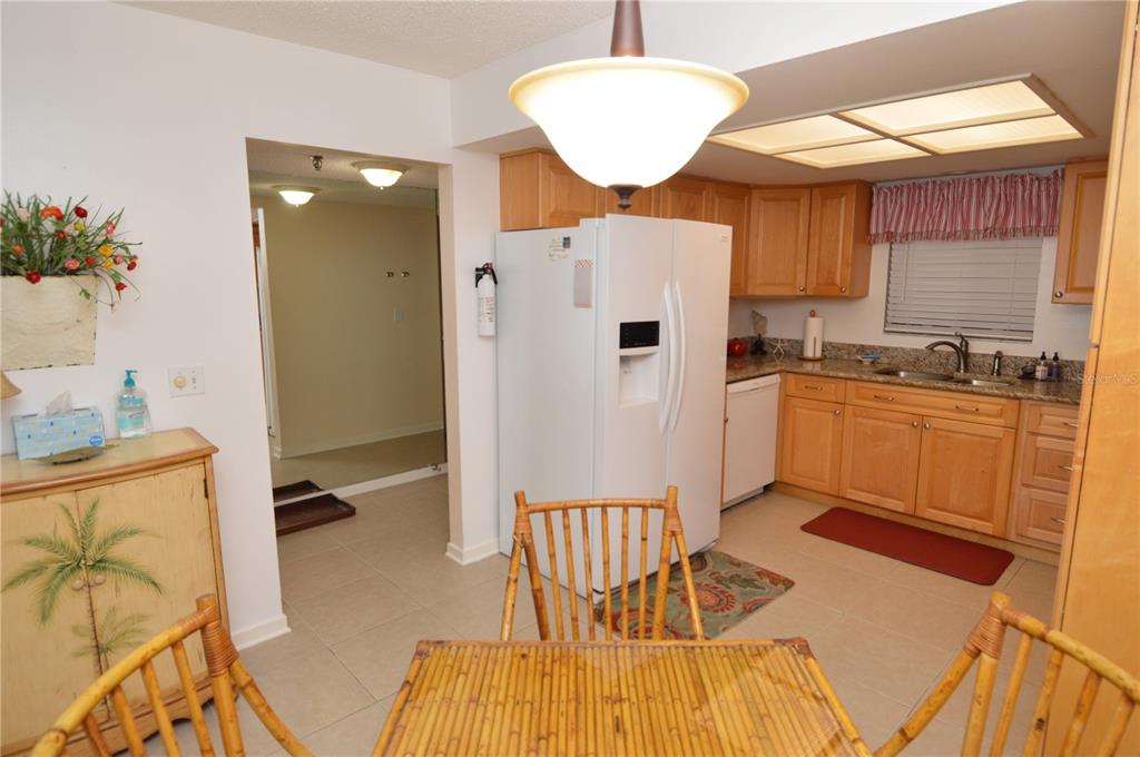 900 Gulf Boulevard, Unit 907 Indian Rocks Beach, FL 33785 - Photo 7 of 88 a kitchen with stainless steel appliances granite countertop a refrigerator a sink a stove and white cabinets