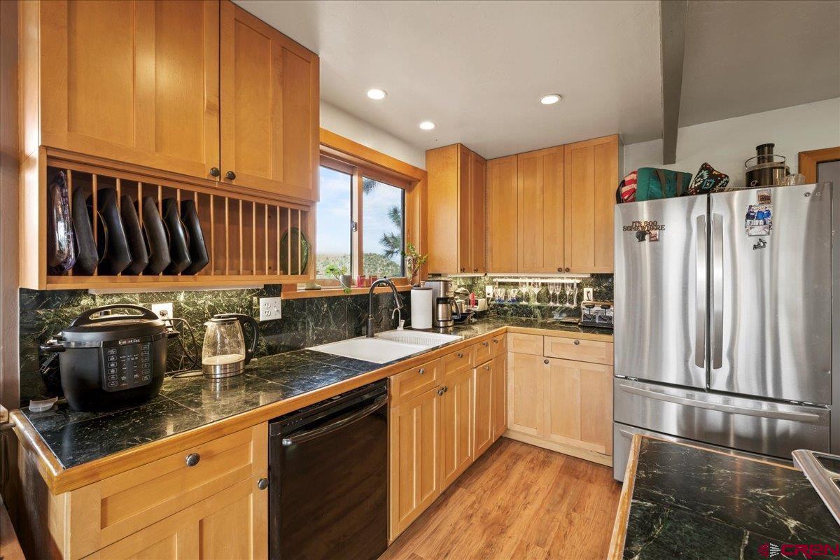 87 Which Way Ridgway, CO 81432 - Photo 24 of 45 a kitchen with stainless steel appliances granite countertop a refrigerator a sink dishwasher a stove with wooden cabinets and floor