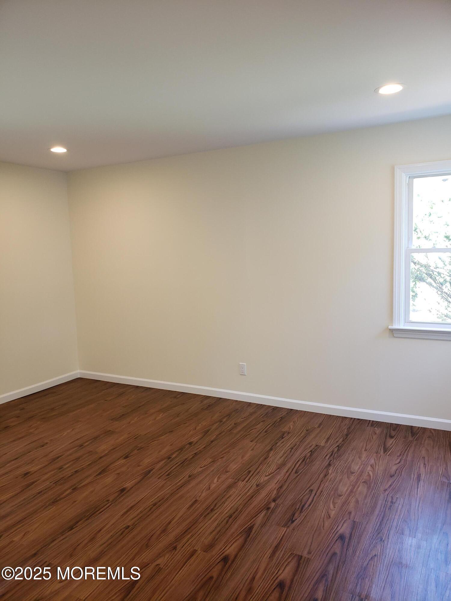 158 Monmouth Road Oakhurst, NJ 07755 - Photo 11 of 19 a view of an empty room with wooden floor and a window