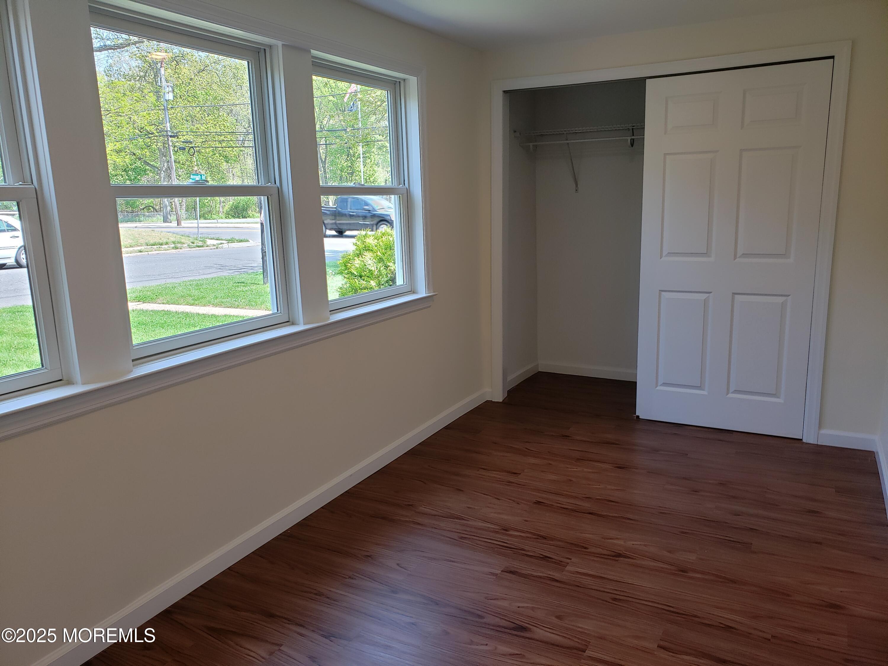 158 Monmouth Road Oakhurst, NJ 07755 - Photo 10 of 19 a view of an empty room with wooden floor and a window