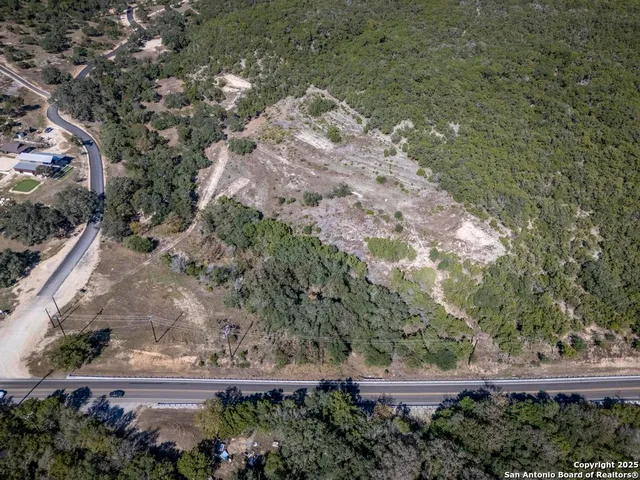 an aerial view of house with yard and mountain view in back