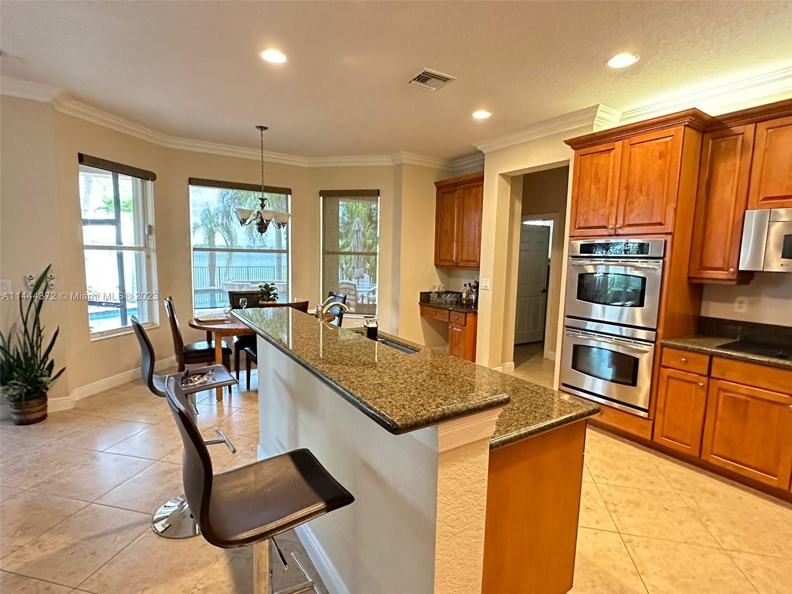 4546 Southwest 179th Way Miramar, FL 33029 - Photo 18 of 55 a kitchen with stainless steel appliances granite countertop sink refrigerator and microwave