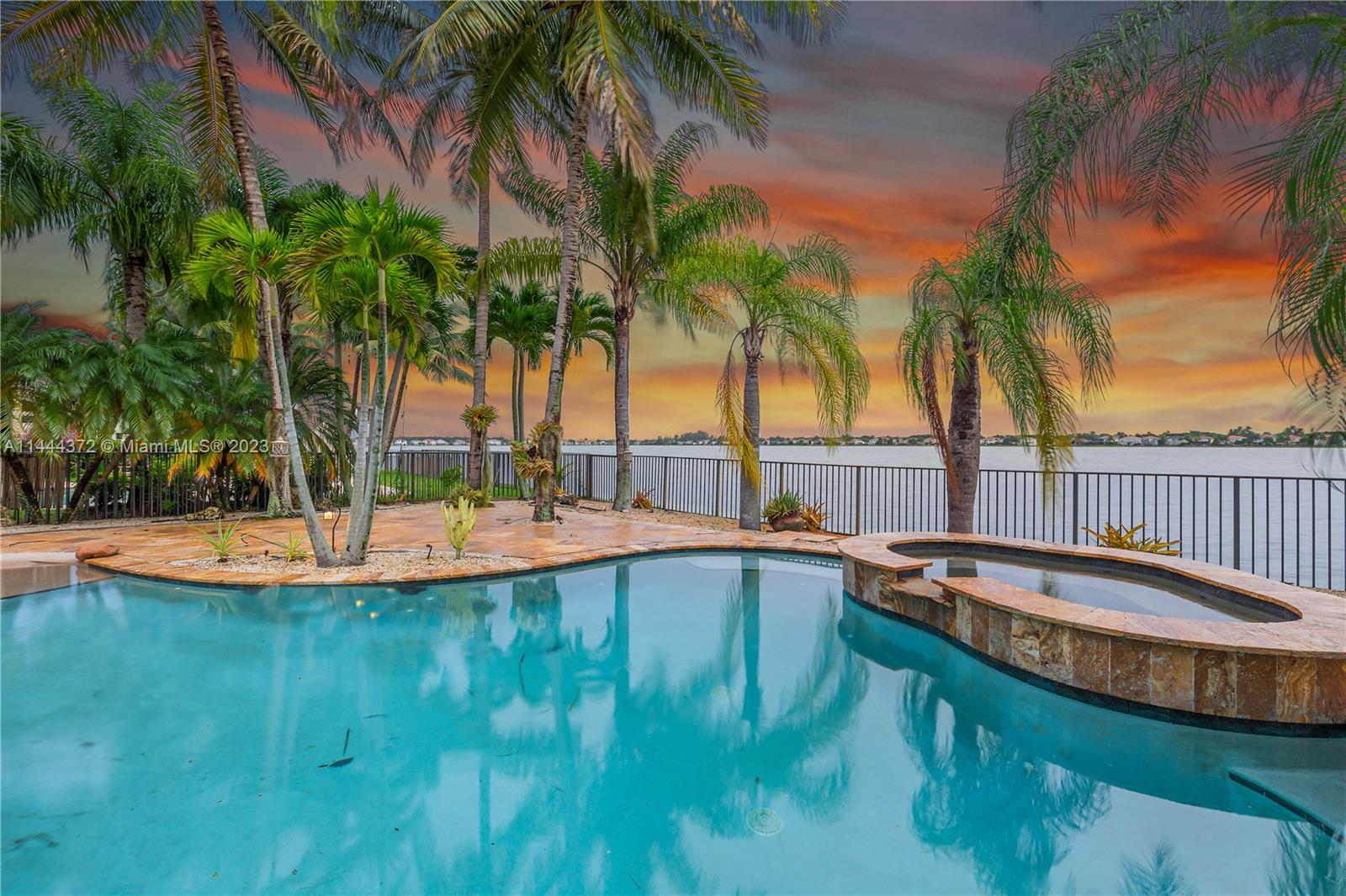 4546 Southwest 179th Way Miramar, FL 33029 - Photo 47 of 55 a view of a swimming pool with a lawn chairs under palm trees