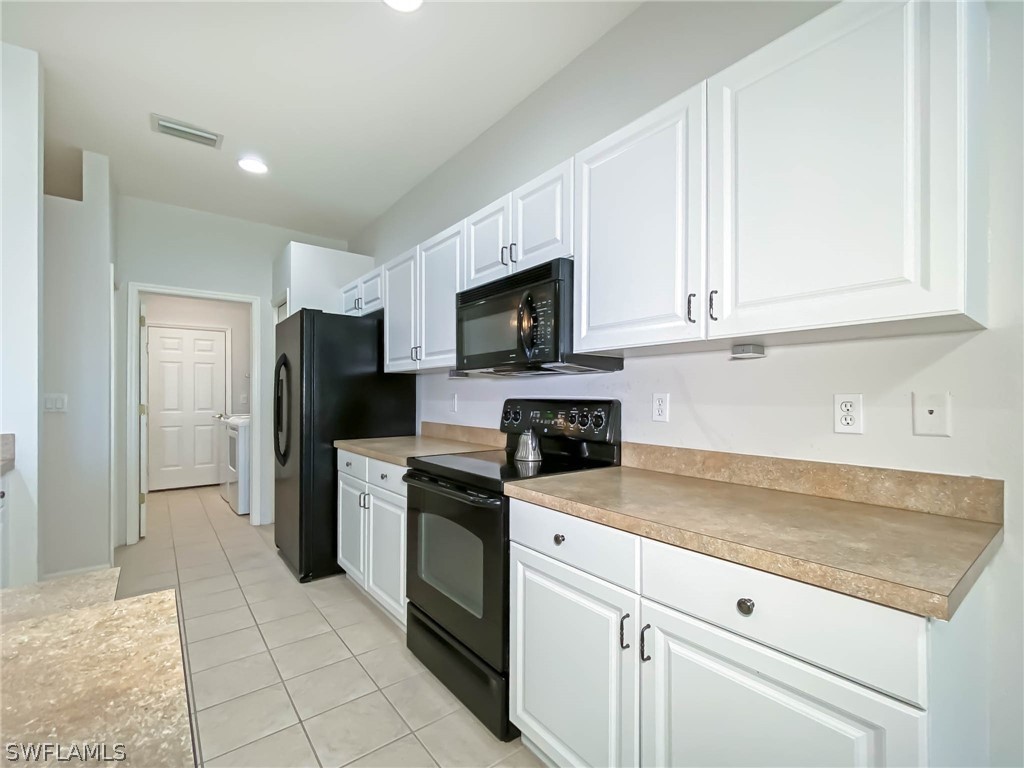 20599 Ardore Lane Estero, FL 33928 - Photo 15 of 29 a kitchen with a stove a sink and a refrigerator