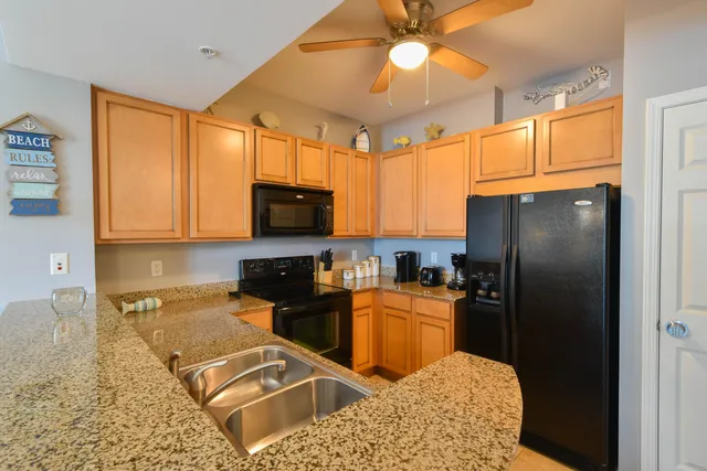 a kitchen with stainless steel appliances granite countertop a refrigerator stove top oven and sink