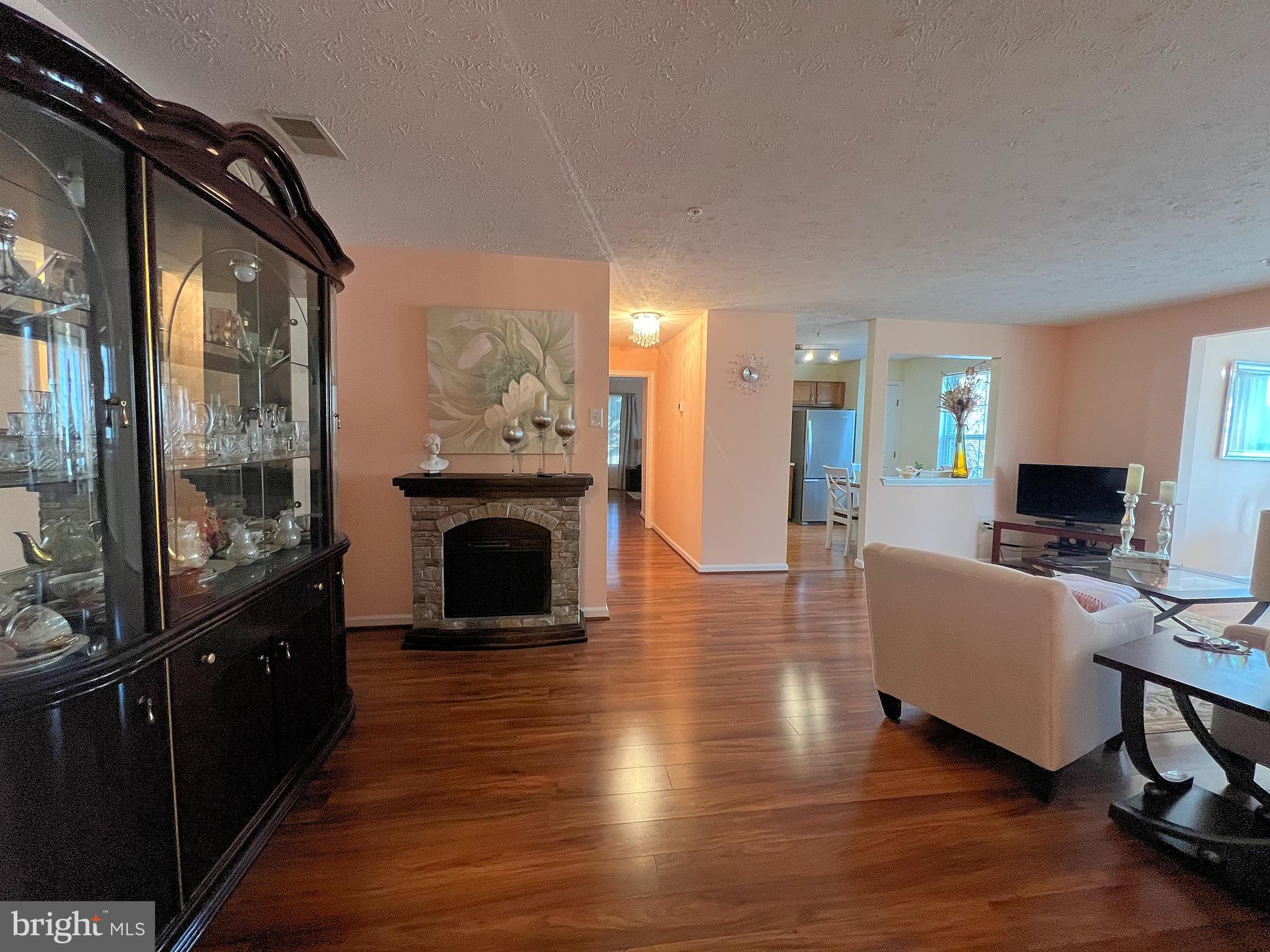 7903 Valley Manor Road, Unit 204 Owings Mills, MD 21117 - Photo 4 of 18 a living room with furniture a fireplace and a flat screen tv