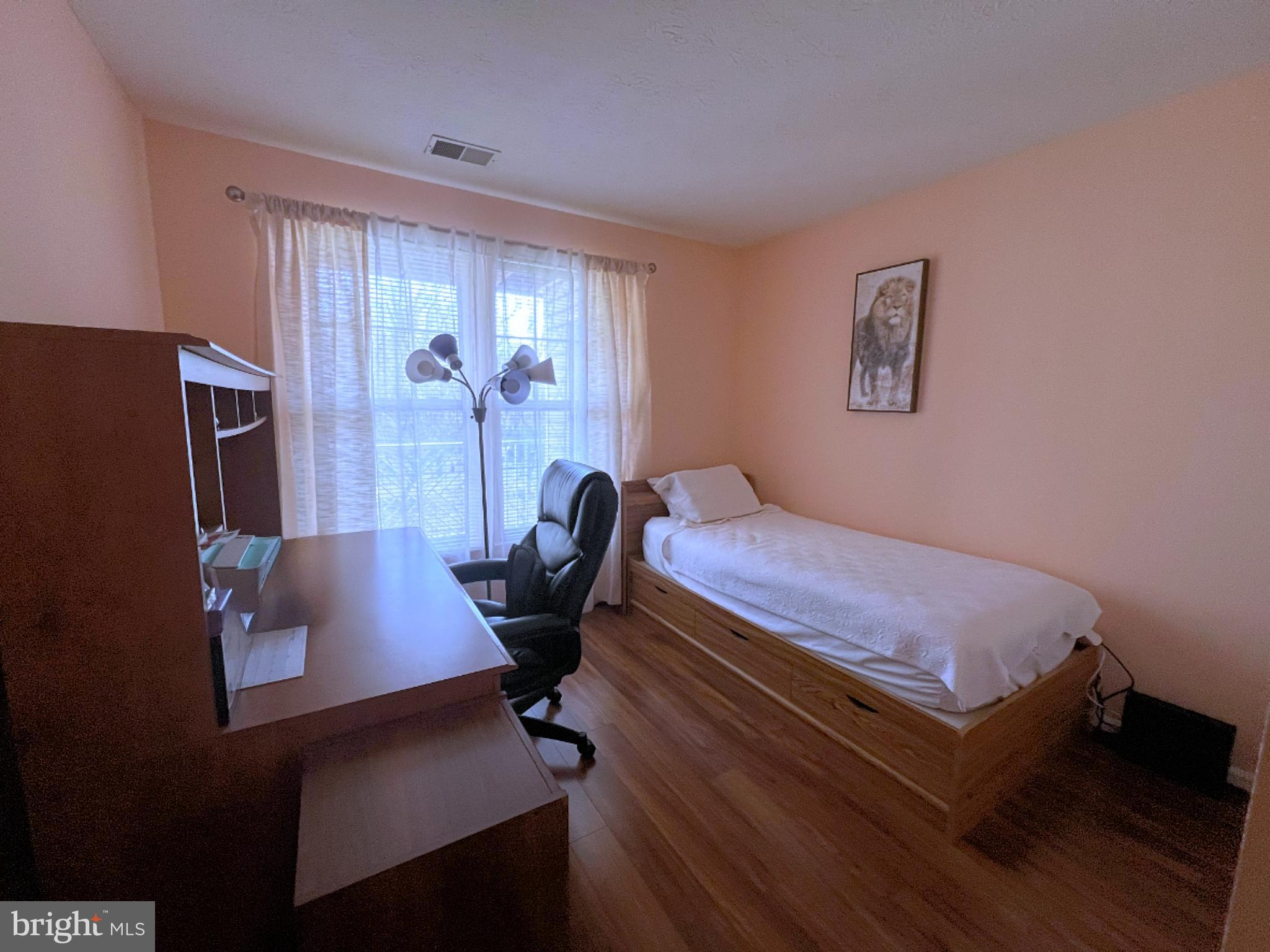 7903 Valley Manor Road, Unit 204 Owings Mills, MD 21117 - Photo 7 of 18 a bedroom with a bed and a desk